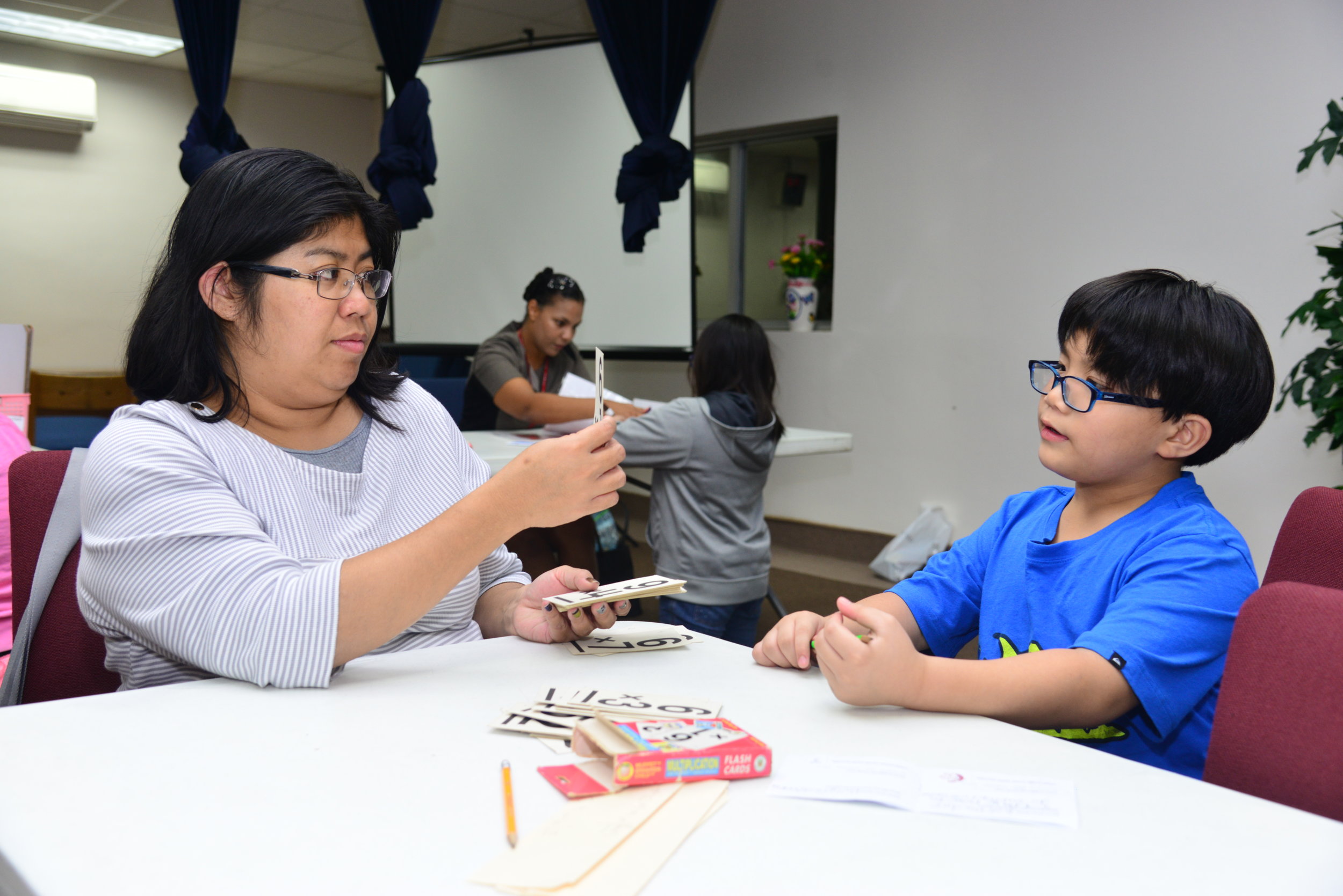 Mom tests EJ's math facts using flash cards.