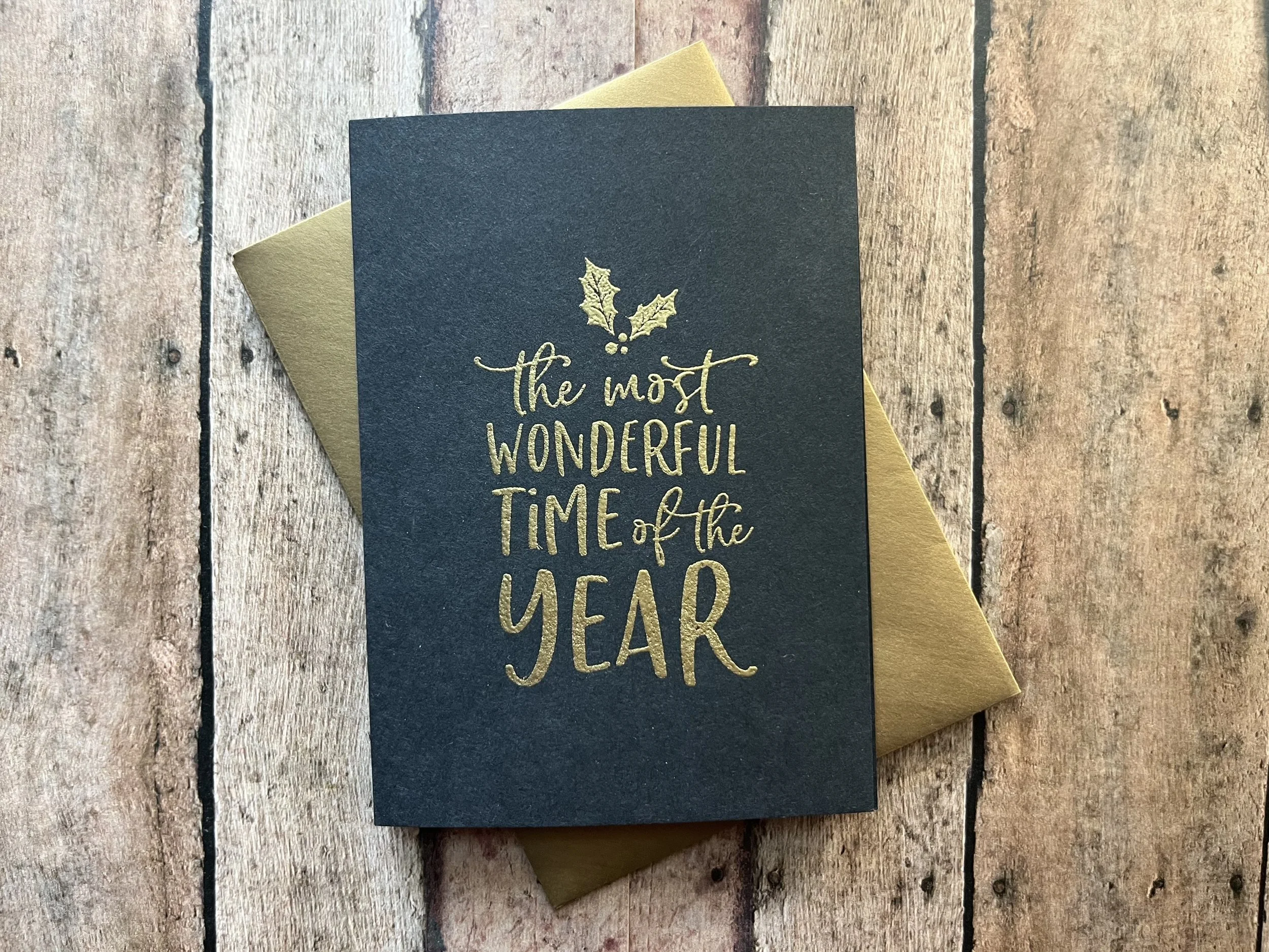 Handmade Christmas Card with Shimmer Gold Ink on Black Cardstock Reading “The Most Wonderful Time of Year,” Paired with a Matching Gold Envelope