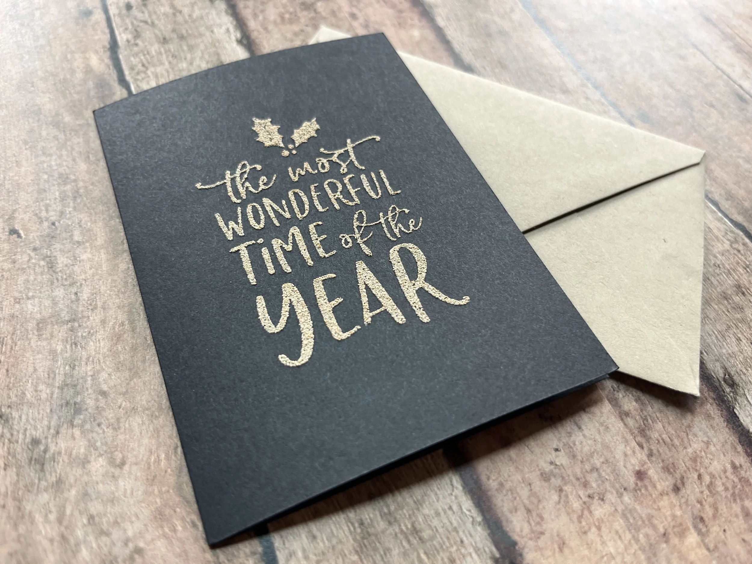 Handmade Christmas Card with Khaki Ink on Black Cardstock Reading "The Most Wonderful Time of the Year", Paired with a Matching Khaki Envelope