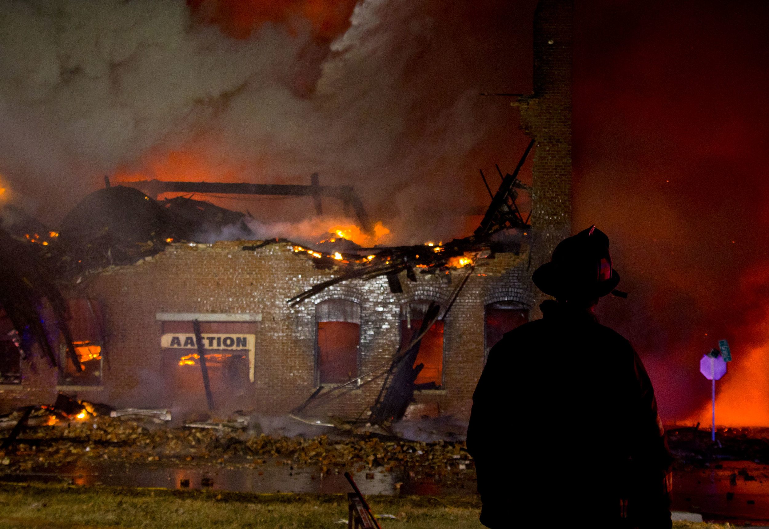  (January 20, 2015) A Decatur firefighter watches as a fire rages on at the Aaction Warehouse Tuesday night. Firefighters were unable to save the building, but were able to prevent damage to neighboring homes. 