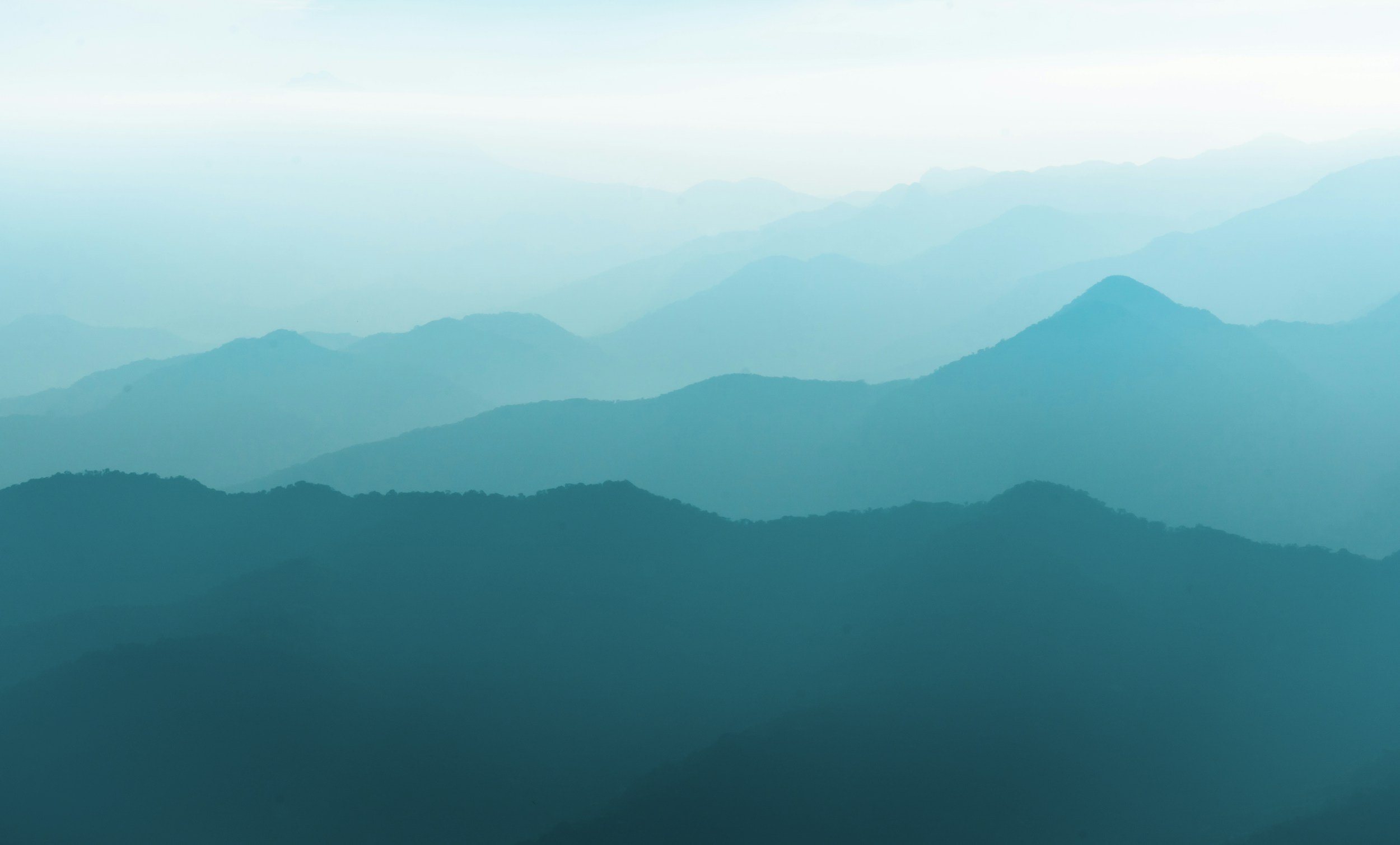 Image of soft blue/teal mountain tops in the distance
