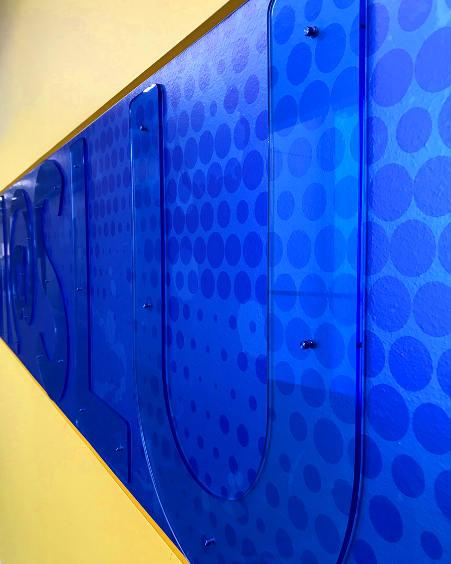  This detail shows how the blue translucent acrylic letterforms are pinned to the wall graphic to add depth. 