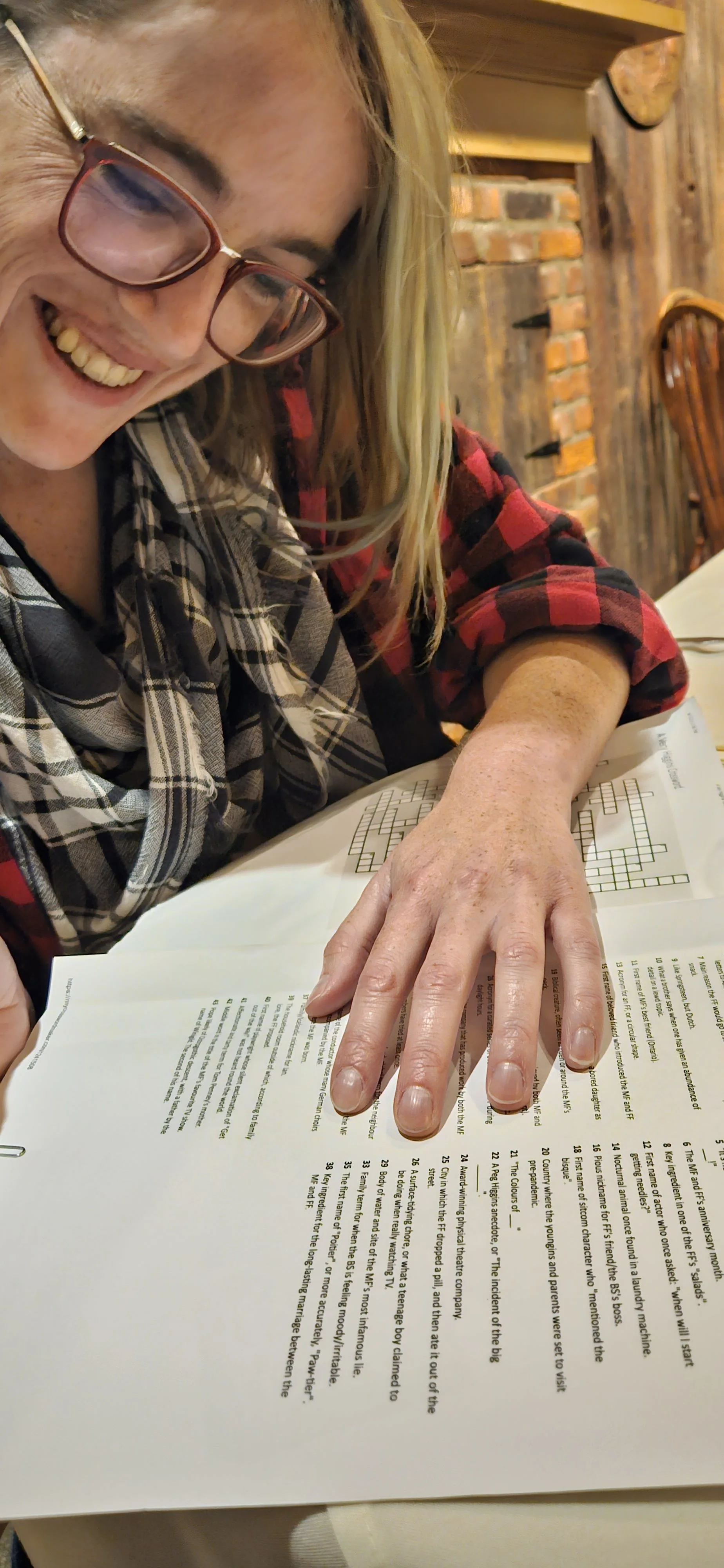 a woman smiles at typed pages of text spread out on a table.