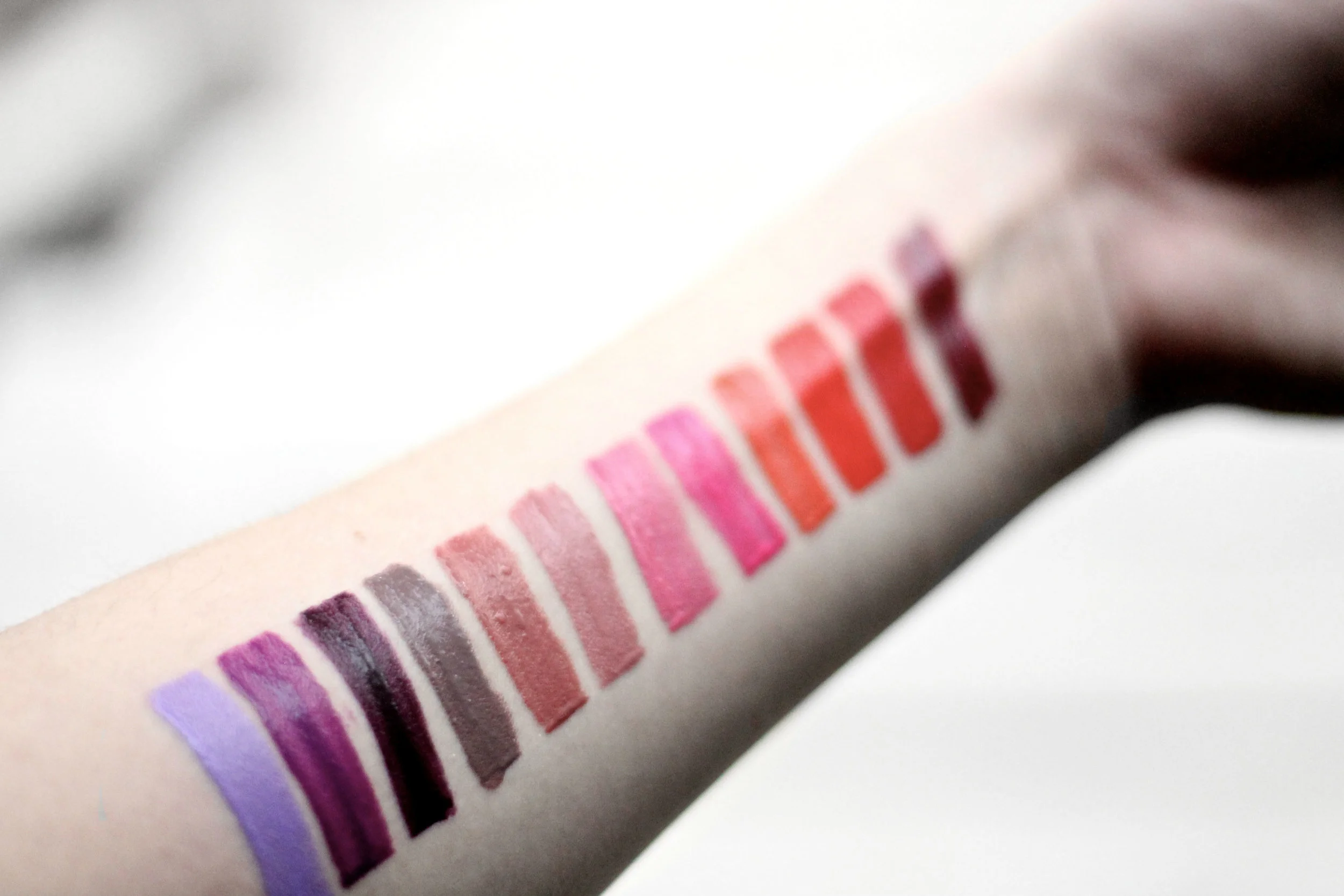 Swatches left to right: Lilac Lust, Violet Twist, Bewitching Bordeaux, Taupeless, Spicy Blush, Nude Star, Wild Rose, Fearless Fuschia, Cool Coral, Orange Envy, DIY Red and Sultry Sangria. 
