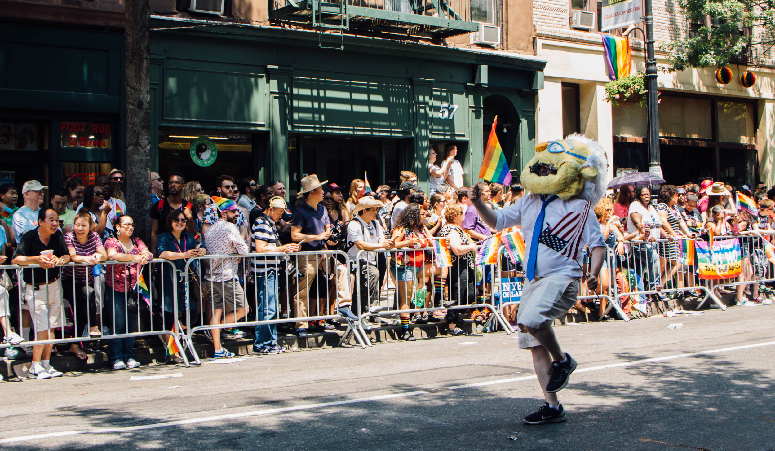 A Bernie Sanders mascot parades down 5th Avenue.