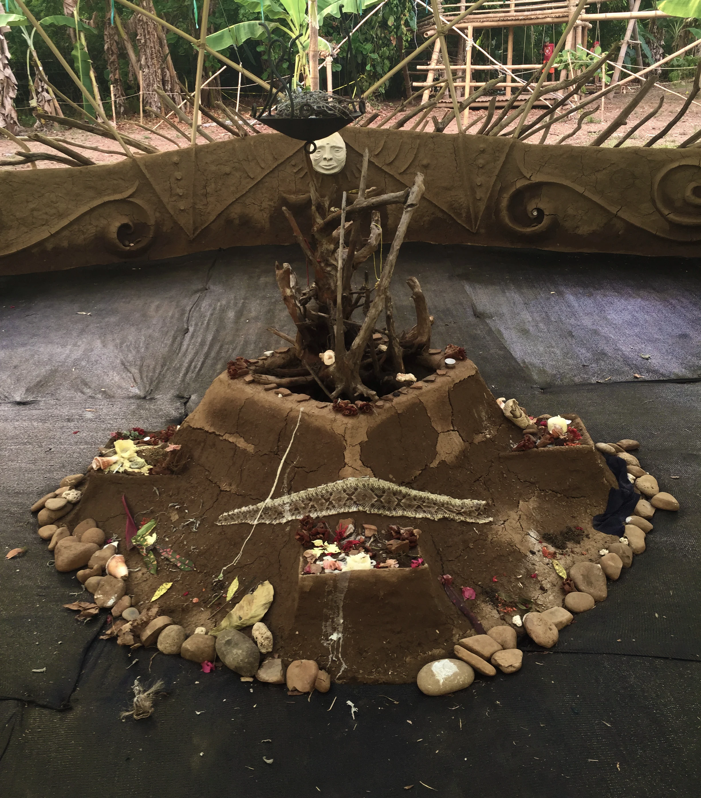 the axis mundi altar : oriented laterally to the four directions and vertically stacking the 5 elements //adorned with offerings left by visitors\\