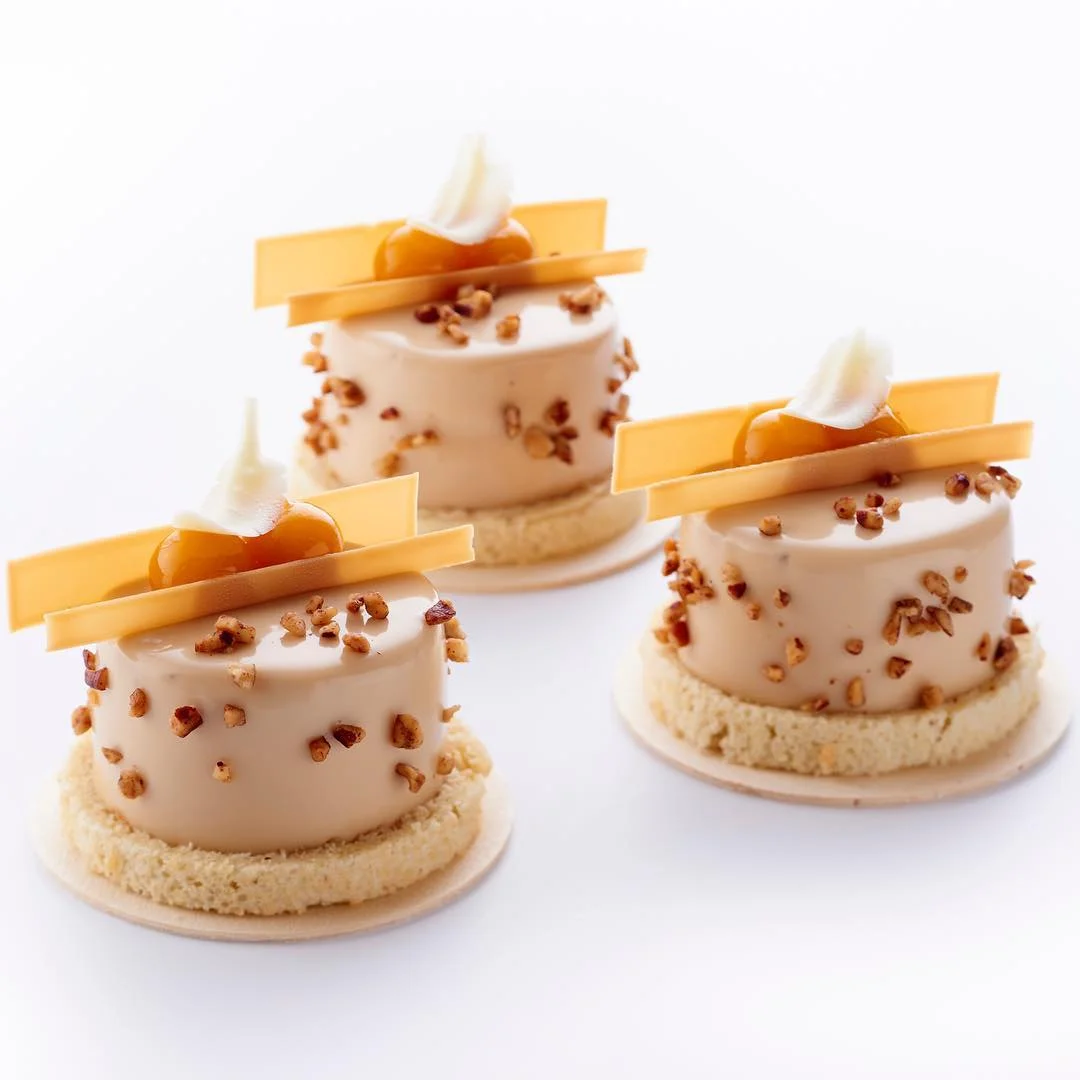 巴黎 Park Hyatte Paris-Vendôme 飯店的甜點主廚 Jimmy Mornet 創作的「entremet noix de pécan & fruits de la passion」(核桃與百香果蛋糕)。蛋糕的淋面與裝飾不管是色彩還是元素,皆完整呼應主成份核桃與百香果。 Photo|Instagram @jimmy_mornet