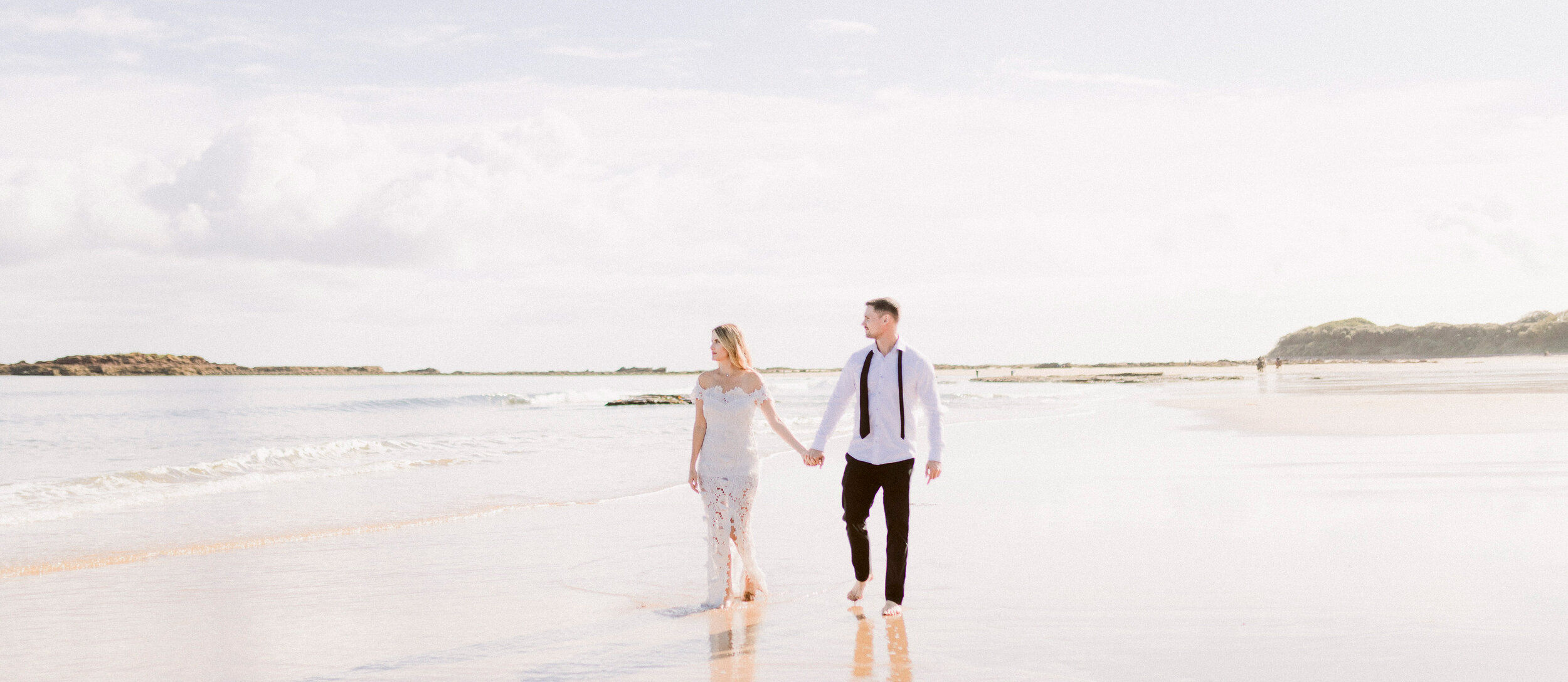 Couple walking on Seacliff Beach during engagement photography session 