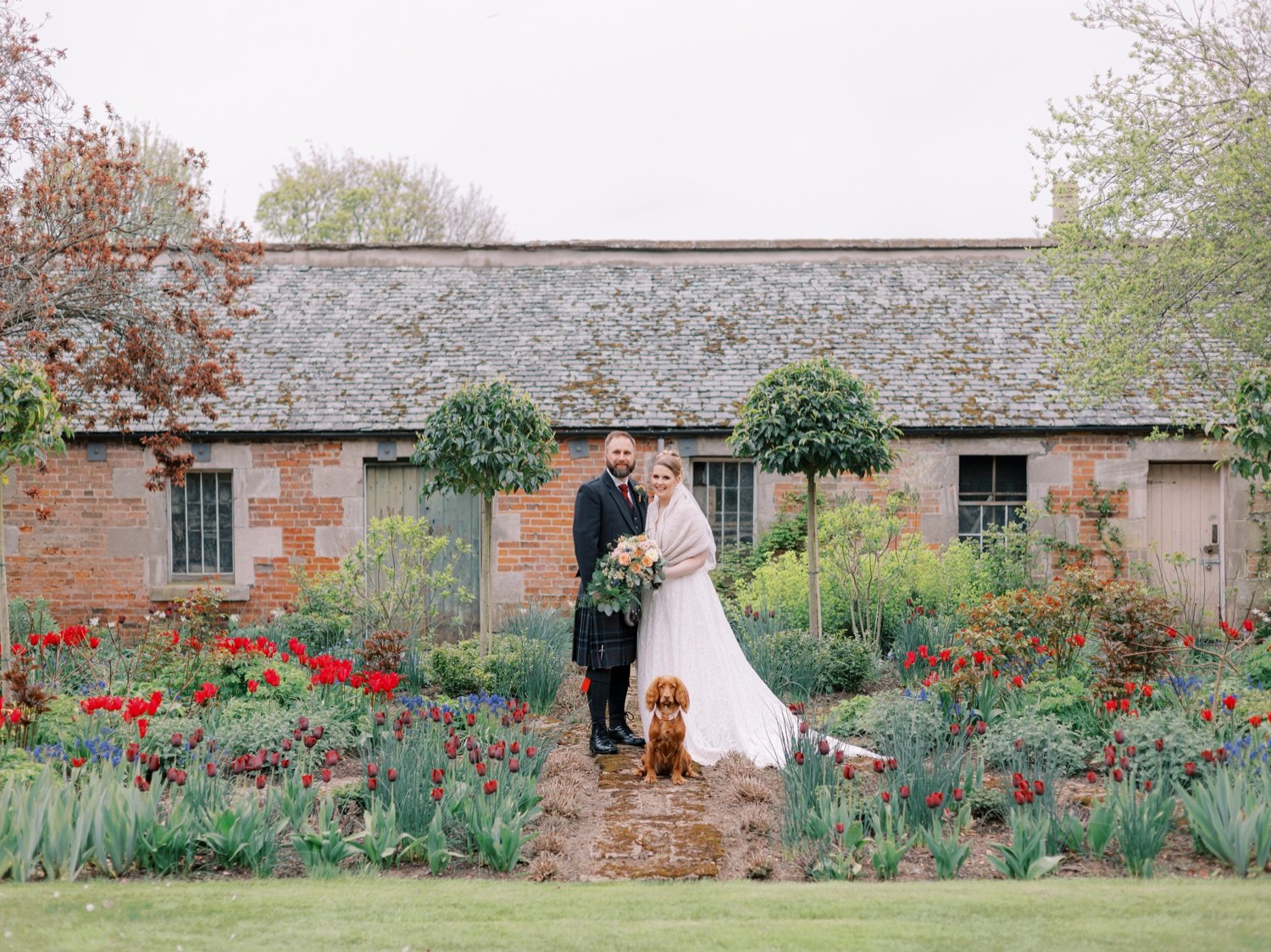 32_bride and groom infront of rustic barn at leuchie walled garden near north berwick east lothian scotland.jpg