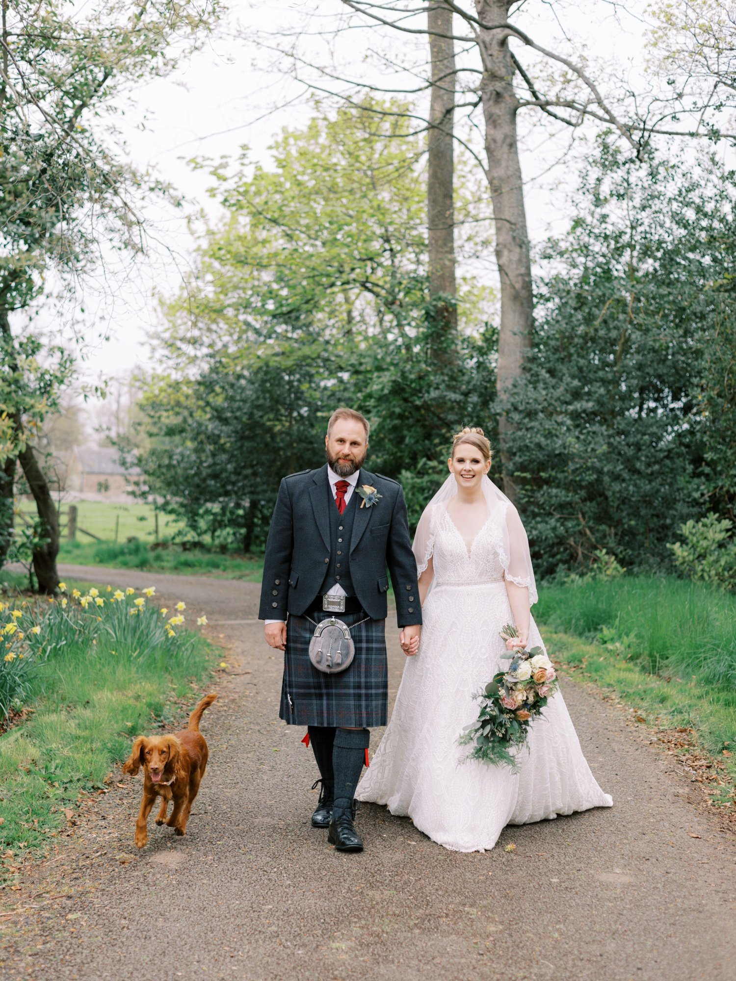 36_bride and groom walking with their dog at leuchie walled garden near north berwick east lothian scotland.jpg