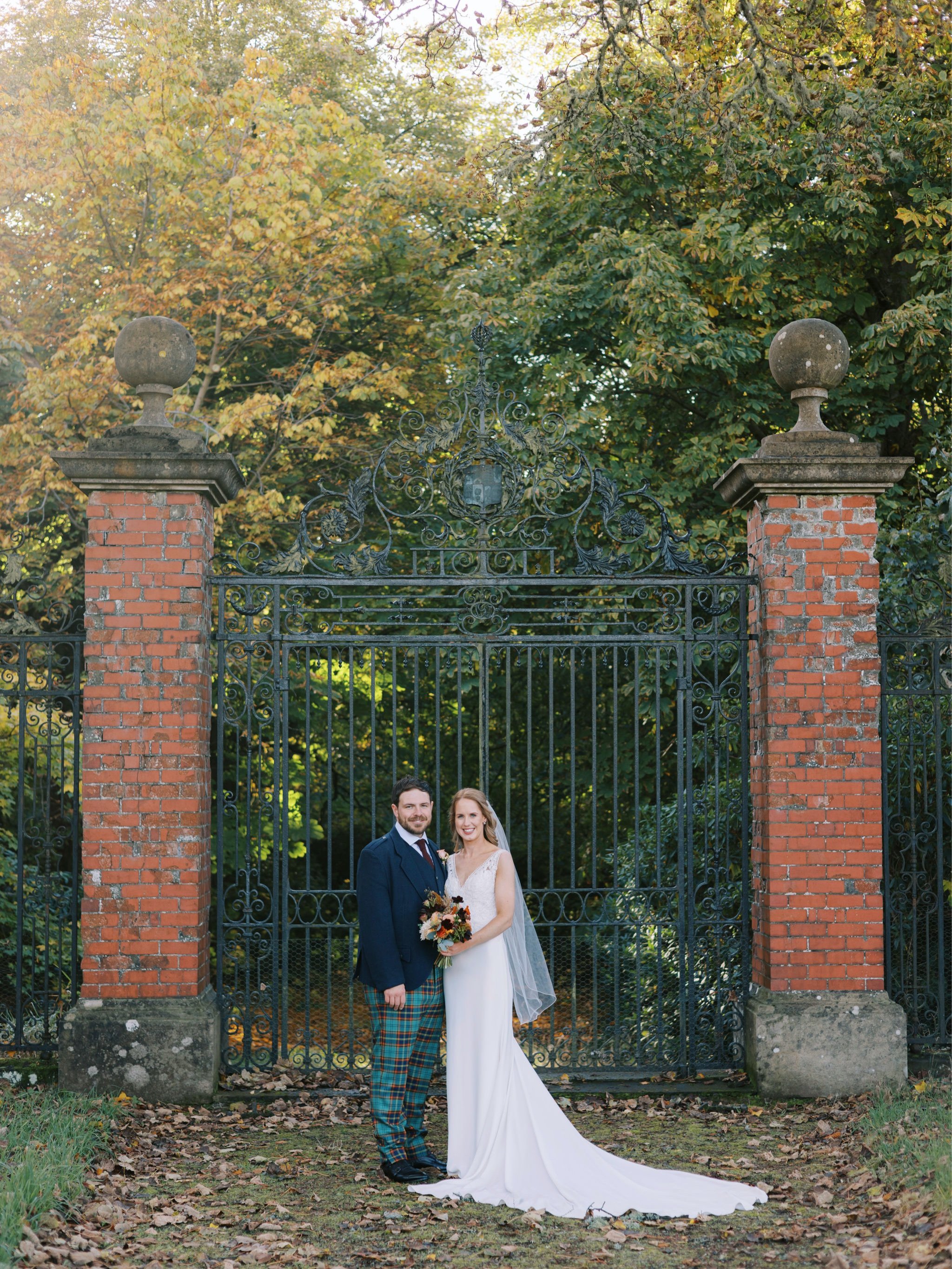 22_wedding photographer kirknewton house stables edinburgh bride and groom infront of rustic iron gate .jpg