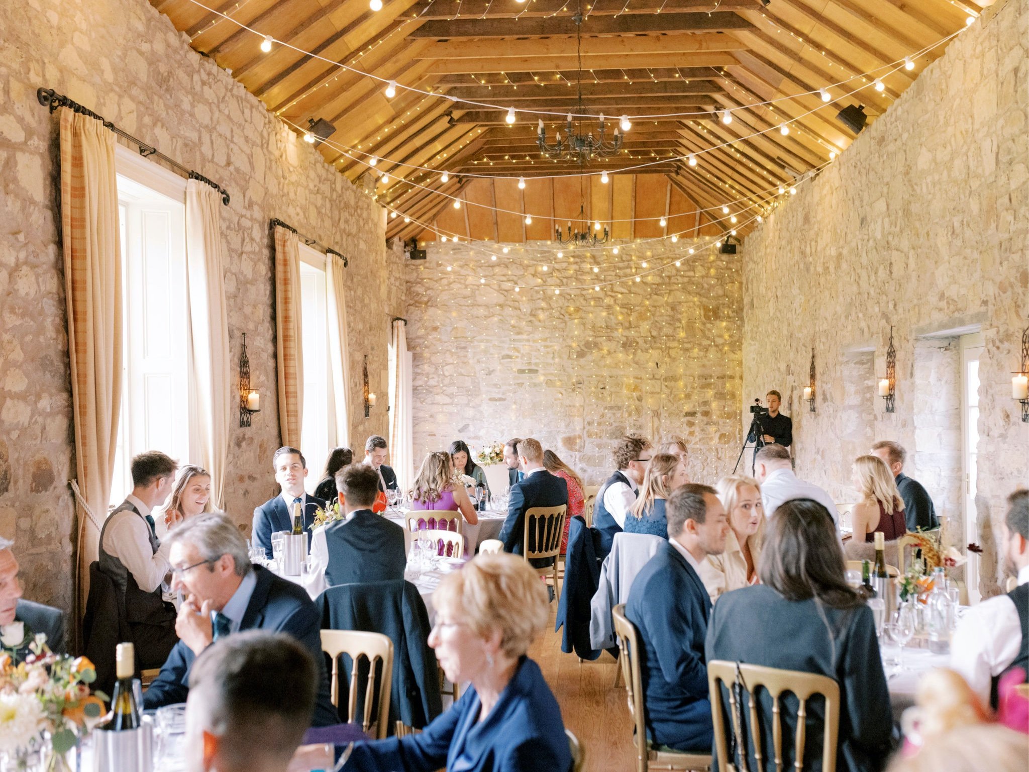 41_wedding photographer kirknewton house stables edinburgh guests seated.jpg