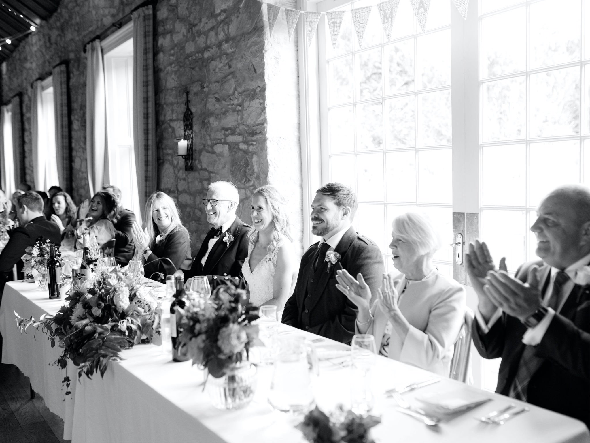43_wedding photographer kirknewton house stables edinburgh bride and groom reacting to speeches .jpg