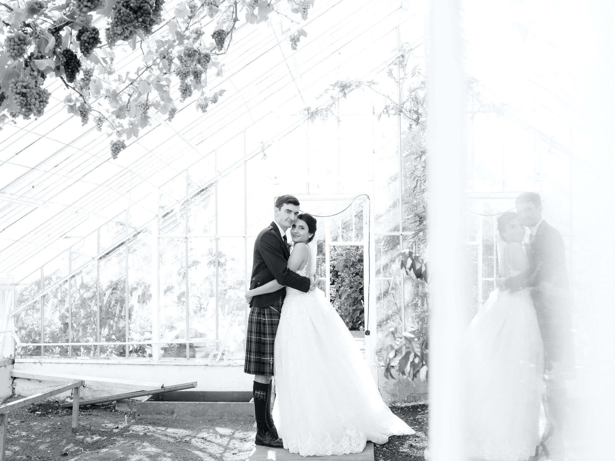 30_carlowrie castle edinburgh wedding photographer bride and groom in greenhouse with reflection.jpg