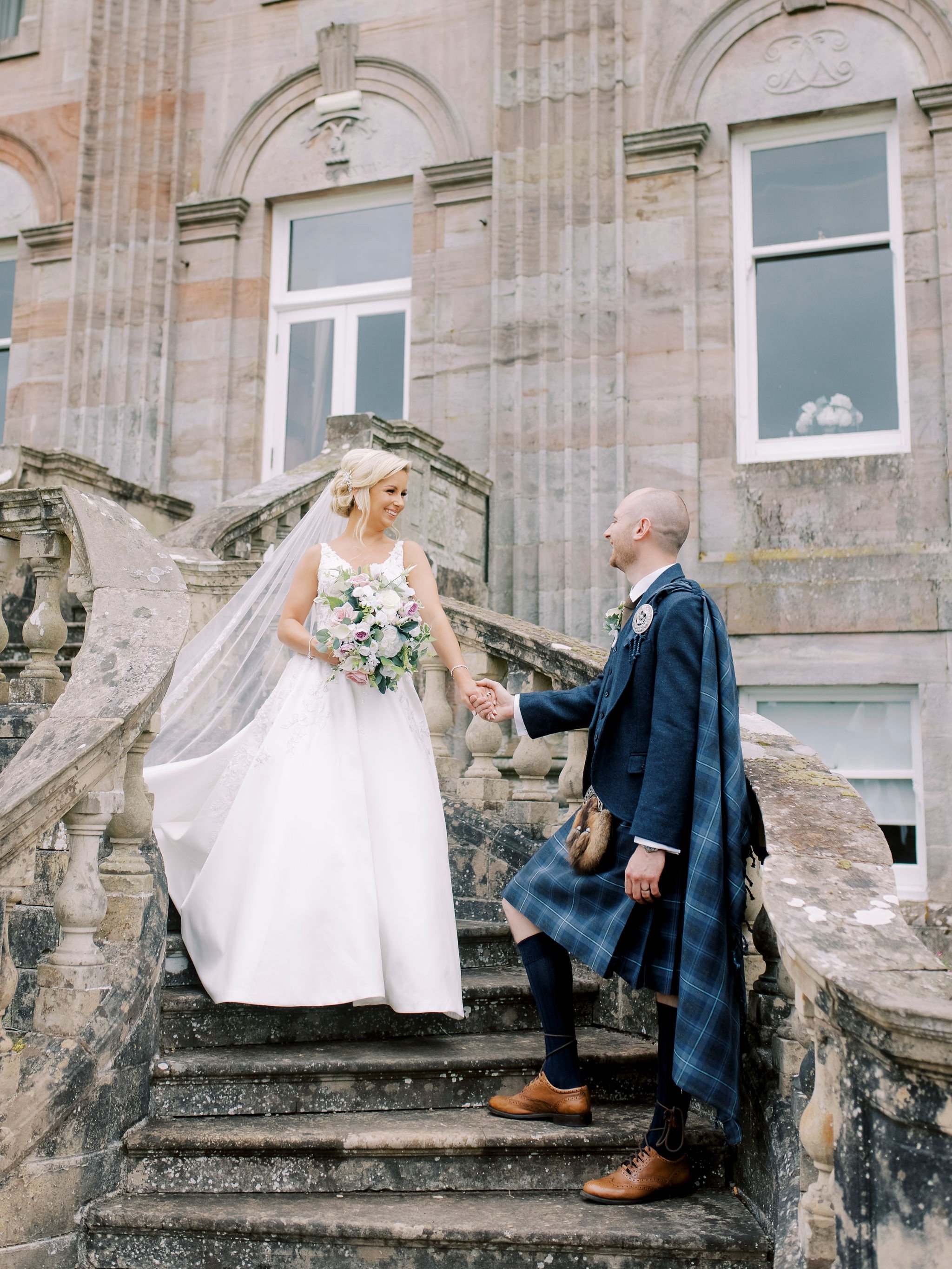 37_springkell-house-wedding-photographer-dumfries-scotland-bride-groom-steps-smiling.jpg