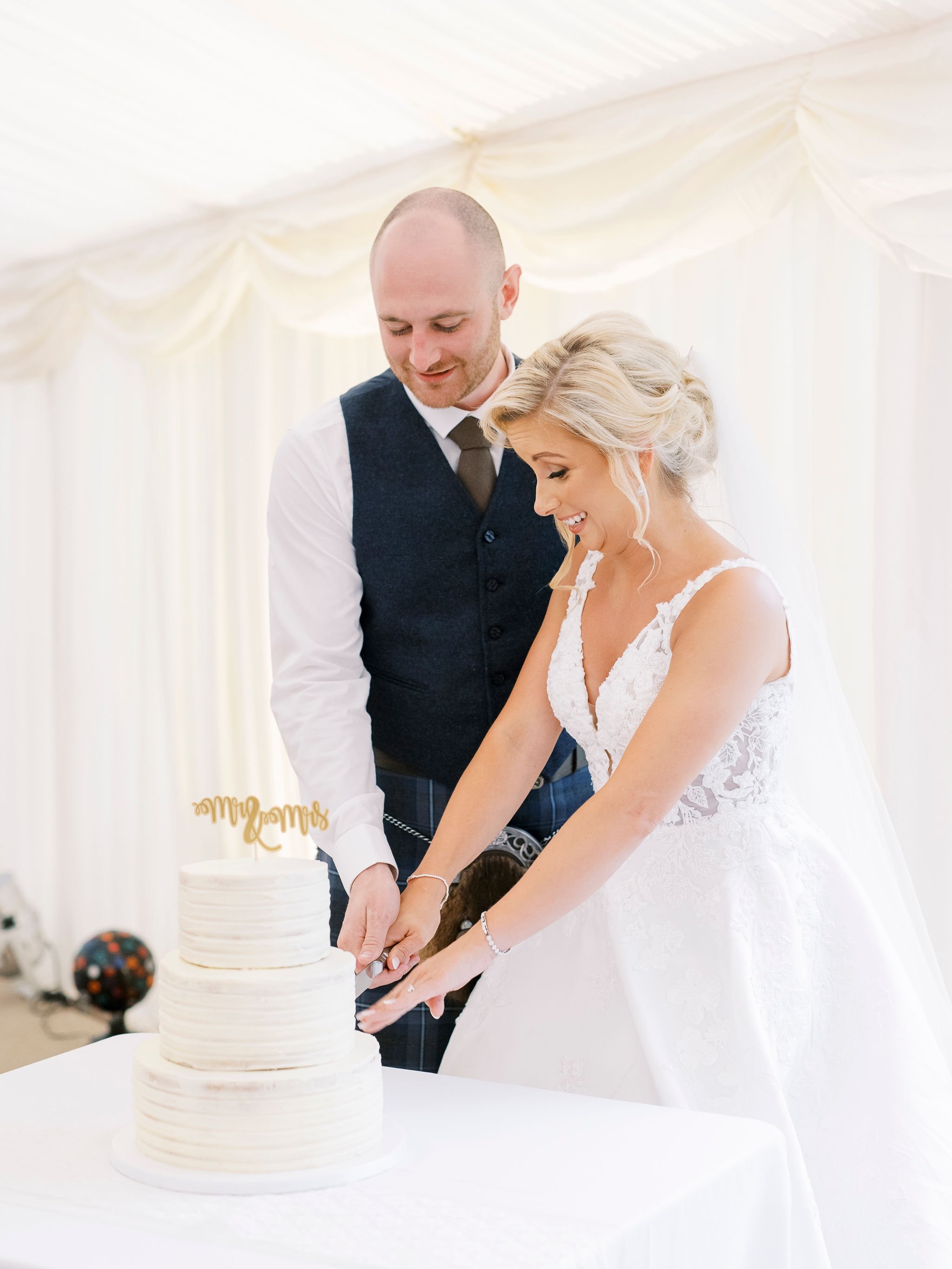 62_springkell-house-wedding-photographer-dumfries-scotland-bride-groom-cut-cake-cutting.jpg