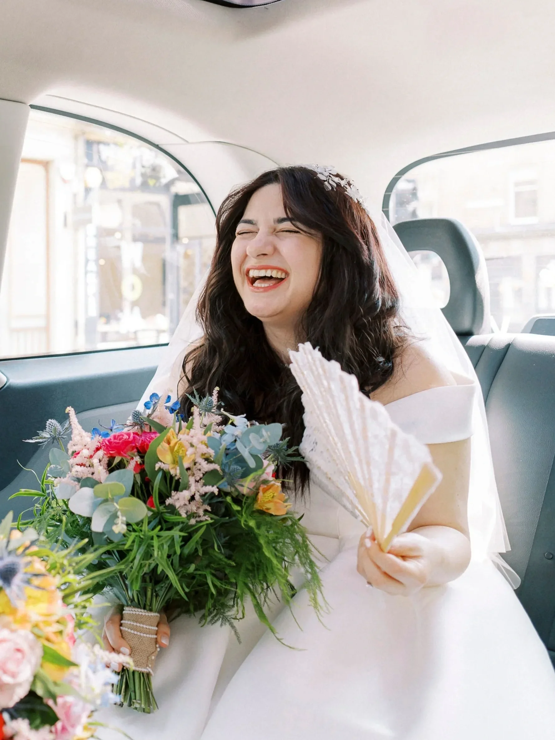 bride laughing in taxi on the way to her edinburgh city chambers wedding
