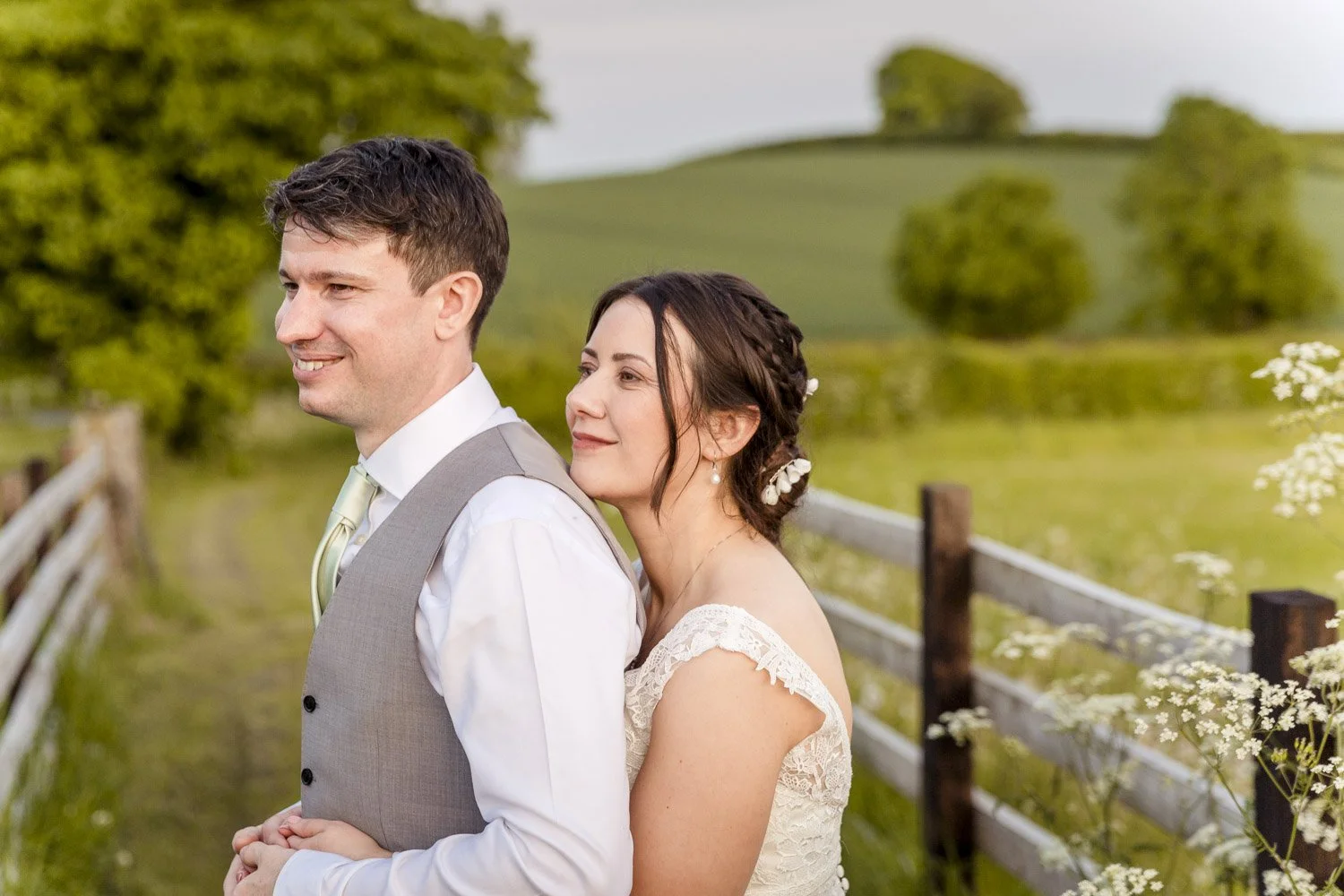 A bride and groom share a private moment with a backdrop of the Derbyshire countryside in front of Donington Park Farmhouse