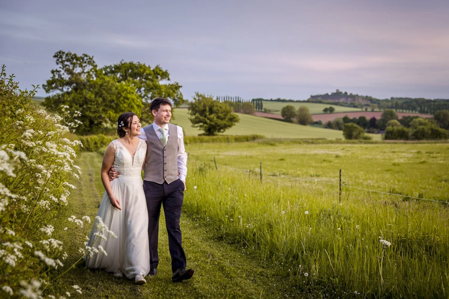 Bride and groom walking in countryside at Donington Park Farmhouse