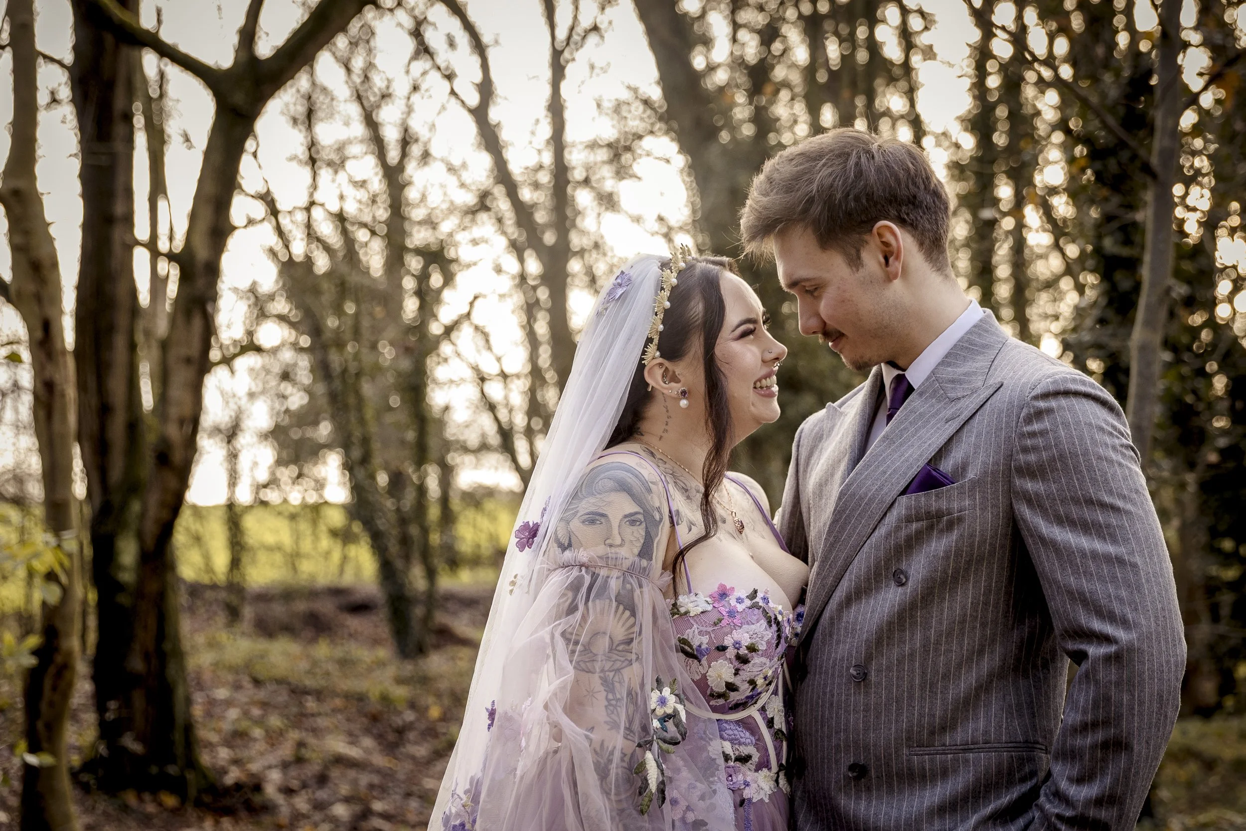 A couple share a romantic moment under the trees at their magical winter wedding at The Woodlands in Leicestershire
