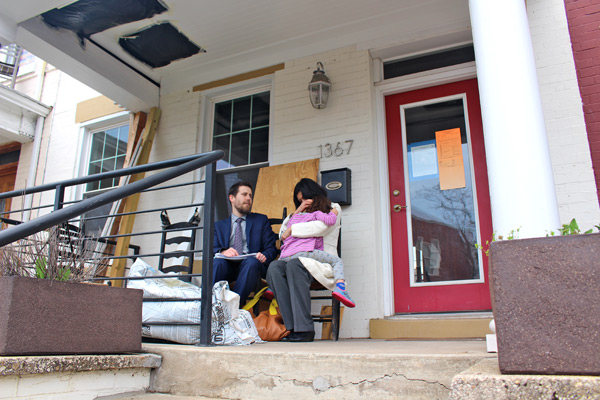 Crampton, Roman and their daughter Ama sitting on the porch of their home in March 2015. After a series of problems with the home, they moved out in Dec. 2013. (WAMU/Martin Austermuhle)