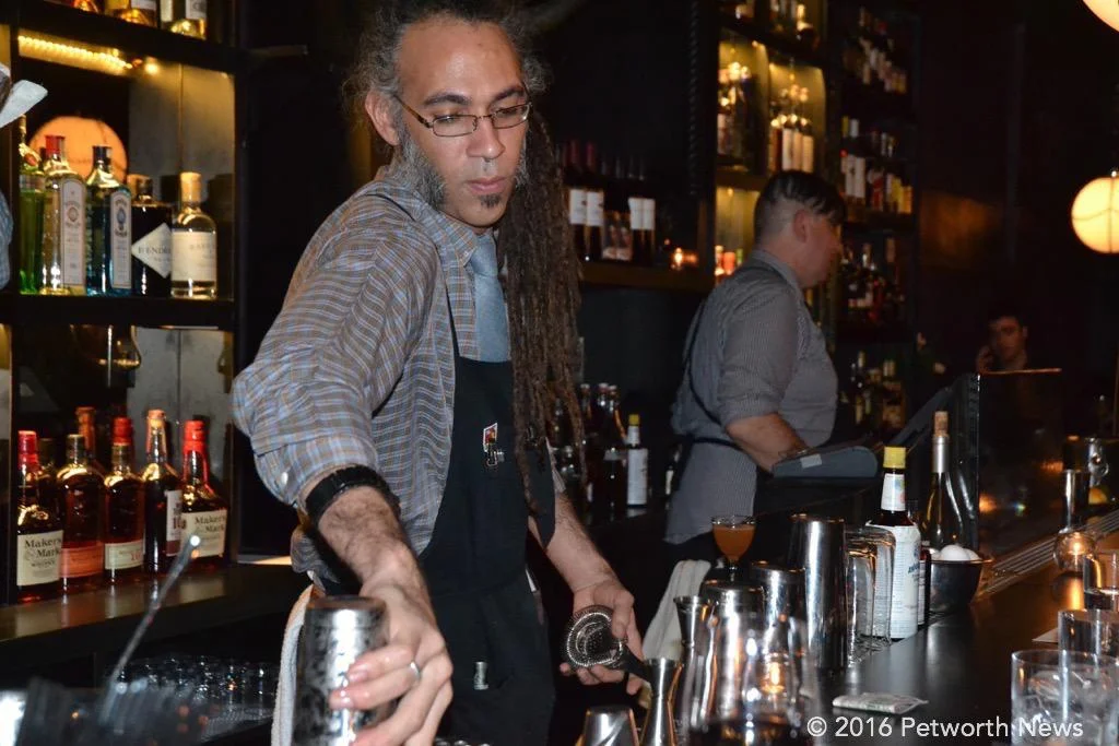 Calvin about to mix another drink, while Burke just served a customer.