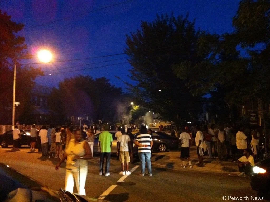 Petworth residents watching a local fireworks display in the street.