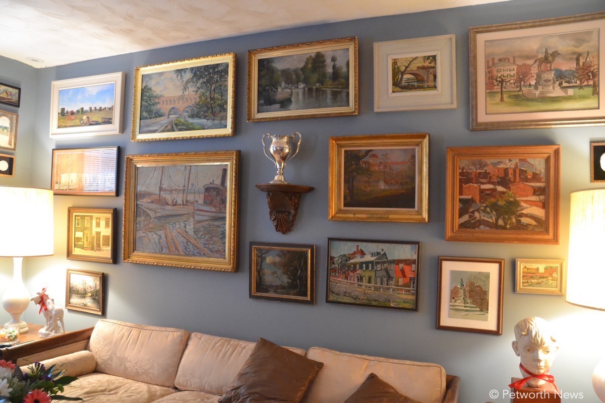 The living room in Kent and Brian's house is covered with paintings from around DC.