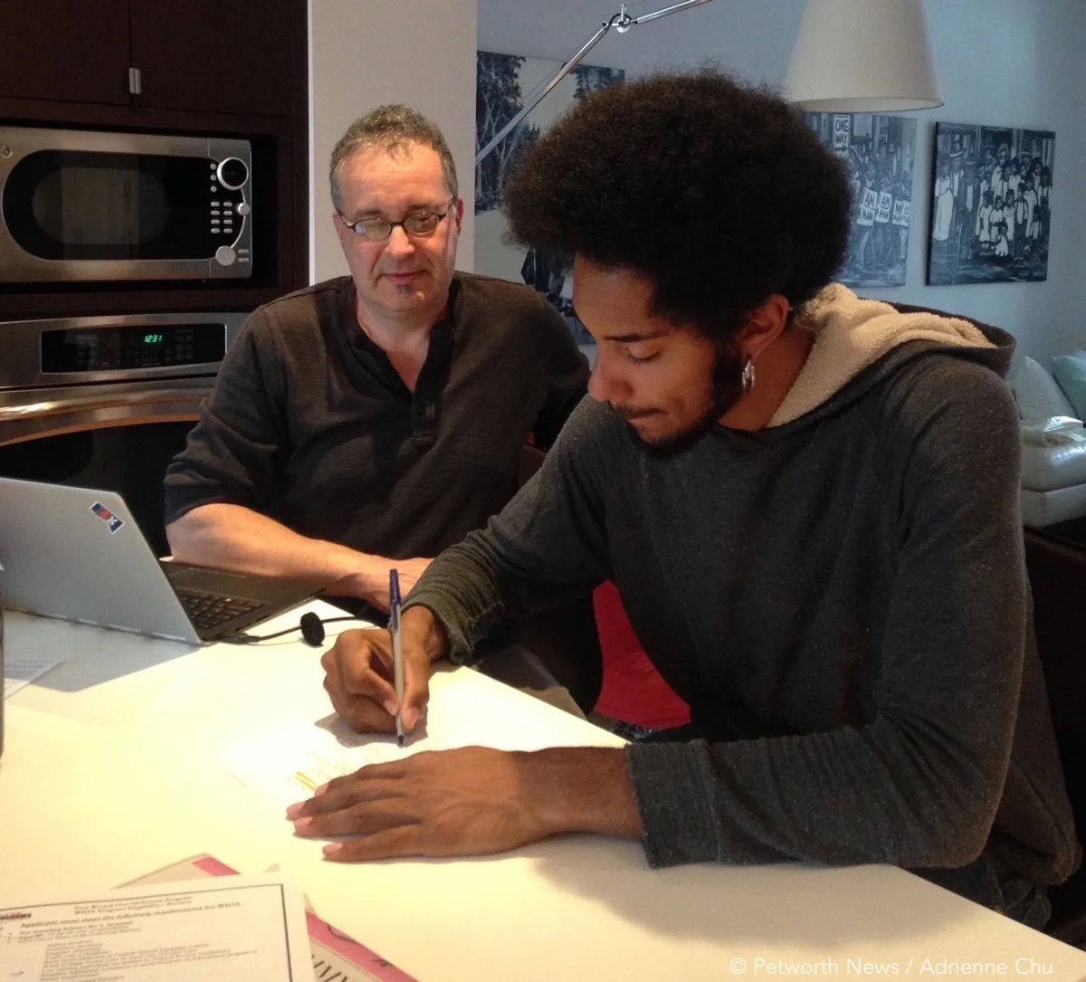 David Sheon, founder of DC Community Carrot, helps Colin Clarke fill out the application for the nonprofit's entrepreneurship program.
