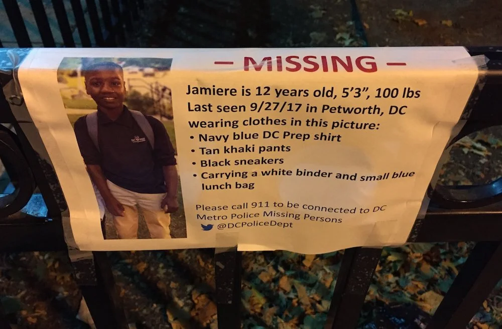 A poster of Jamiere taped to a sign at a park.