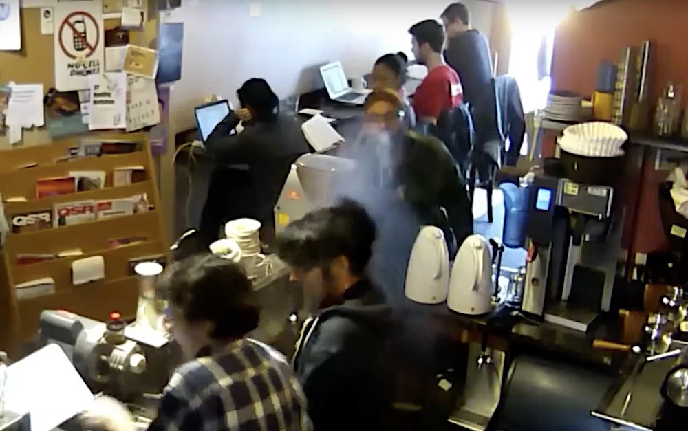 Man seen spitting water at a Qualia employee (screen capture from survellance video.)
