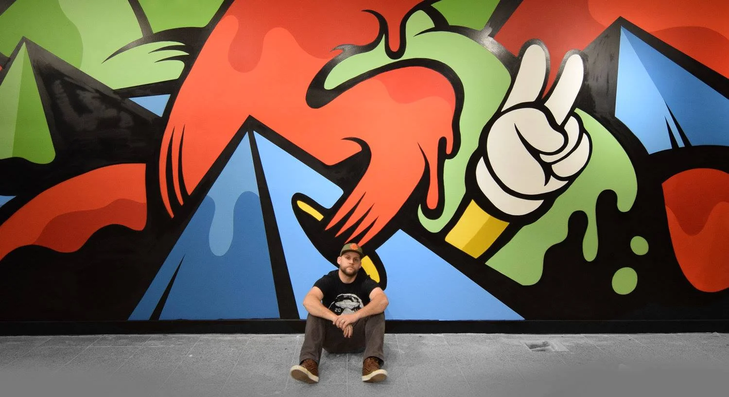 Matt Corrado in front of his artwork