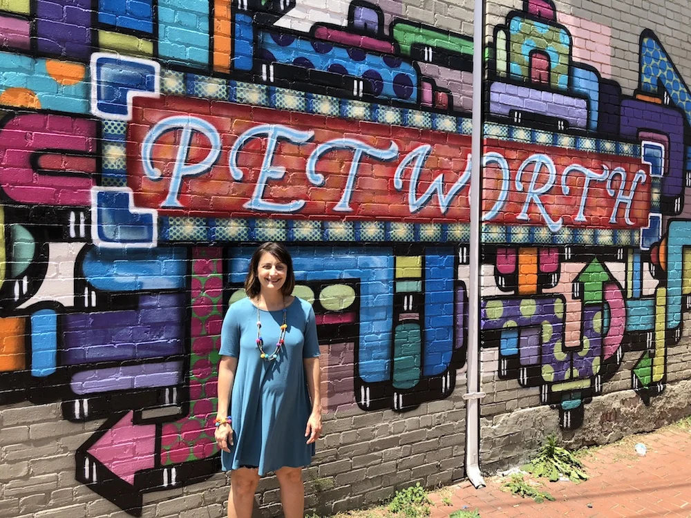 Amy Hemingway, ANC 4D06 Commissioner poses at the Petworth mural.