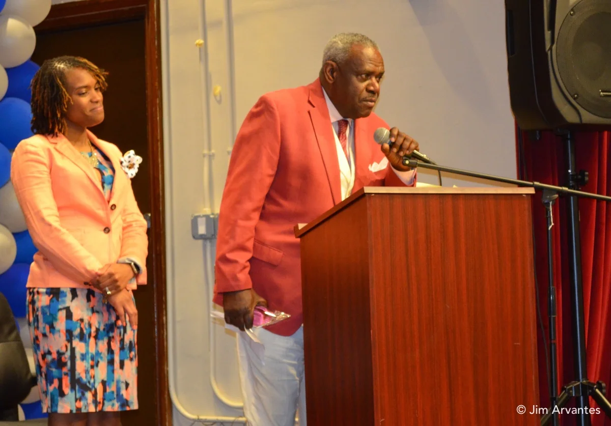 Ted Hinton accepts an award for his long service to Powell. O'Kiyyah Lyons-Lucas, the principal at Powell, stands to Hinton's right.