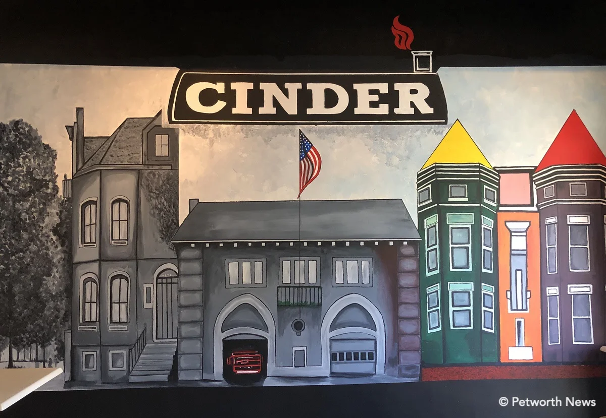 The mural in the back room of Cinder goes from grey into full color as it moves toward the light of the windows. You might recognize the firestation at the center…