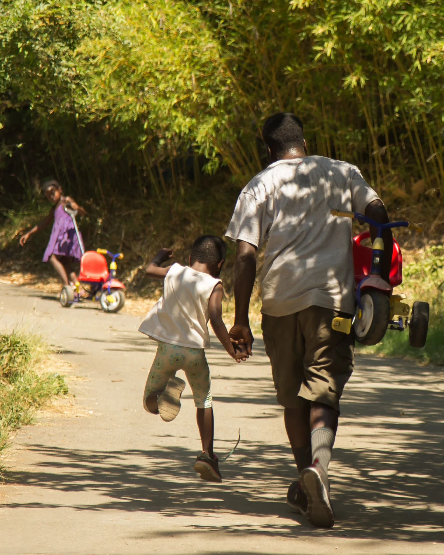 Laura's husband AJ and one of their daughters make another trek up the hill for the bicycle/tricycle race.