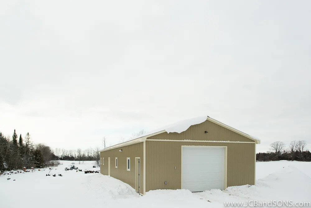 Completed exterior of Southgate honey shed addition with two-tone tan and coffee steel siding and cream trim, built for beekeeping and honey extraction.