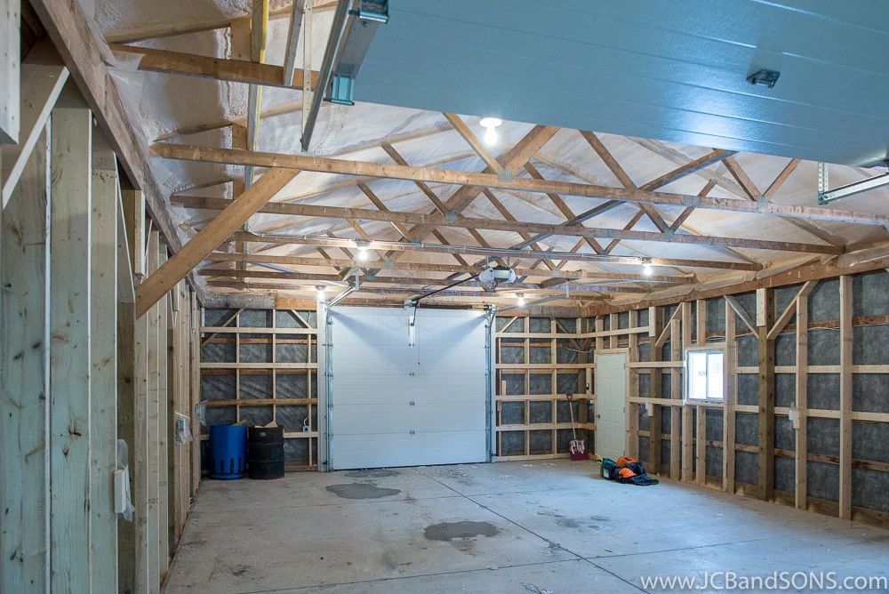 Warehouse area inside honey shed addition near Durham with new cement slab, roof insulation, and framed perimeter walls for future use storing beehives.