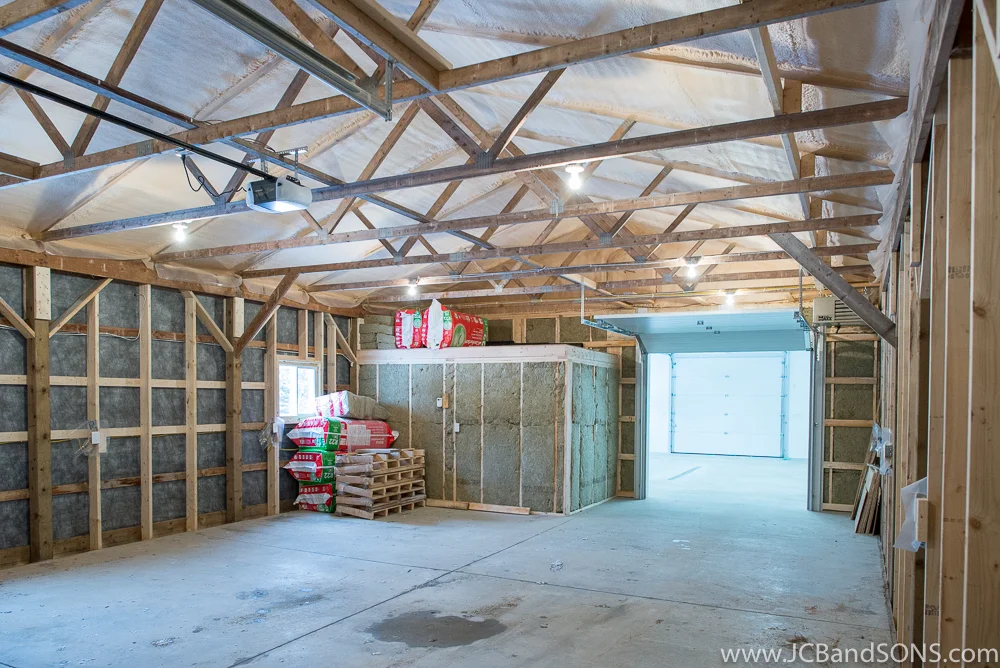 Warehouse area inside honey shed addition near Durham with new cement slab, roof insulation, and framed perimeter walls for future use storing beehives.