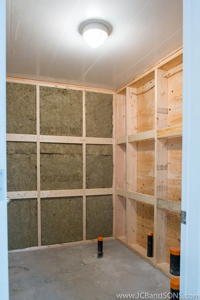 Framed wash-up area in Southgate honey shed with Rockwool insulation, stubbed-in shower drain, Trusscore ceiling panels, and overhead lighting.