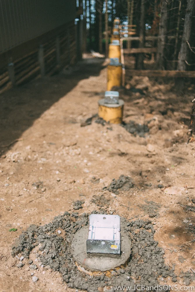 The piers were filled with cement and 2 pieces of 15mm rebar to make strong supports as well as carport saddles were installed to anchor the new structure to the base.