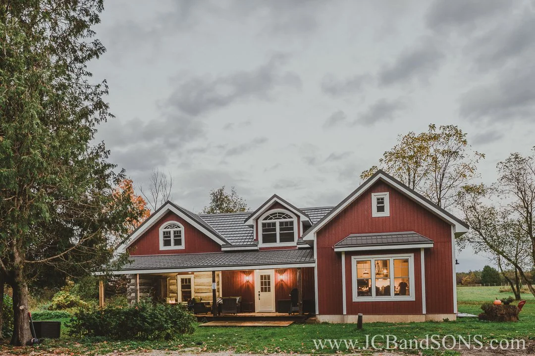 Completed blended transition between original log structure and newly built red-sided addition with matching roofline