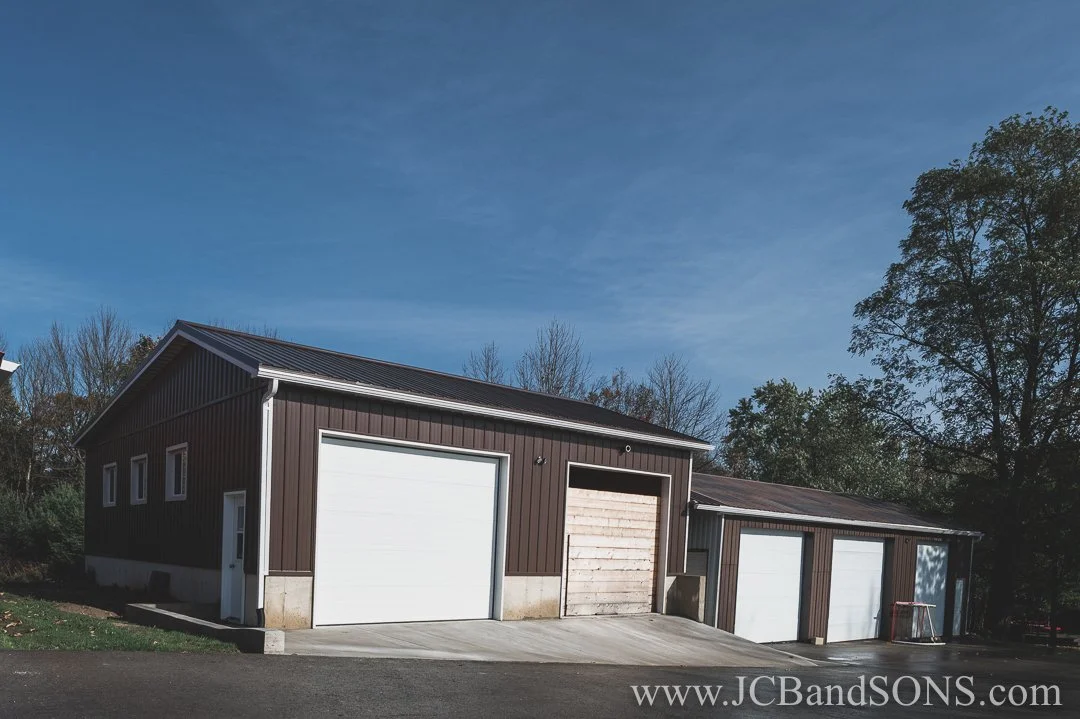 Completed concrete apron and curb poured in front of existing two-bay driving shed in Durham, West Grey