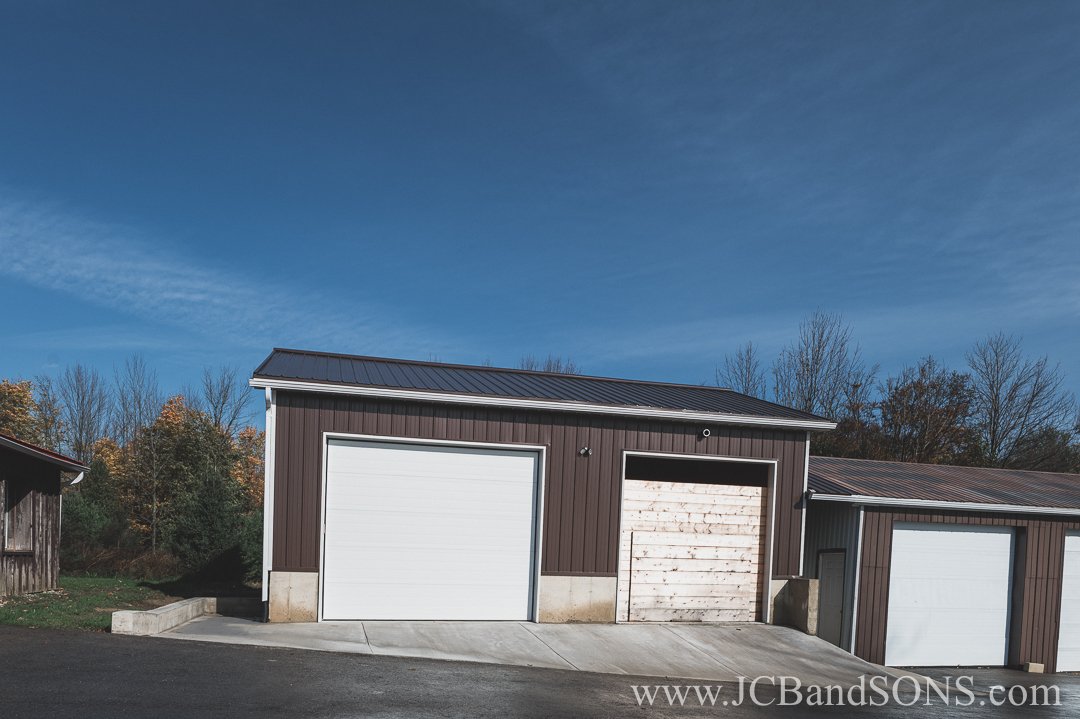 Completed concrete flatwork around existing driving shed in Durham, Ontario, completed under clear skies