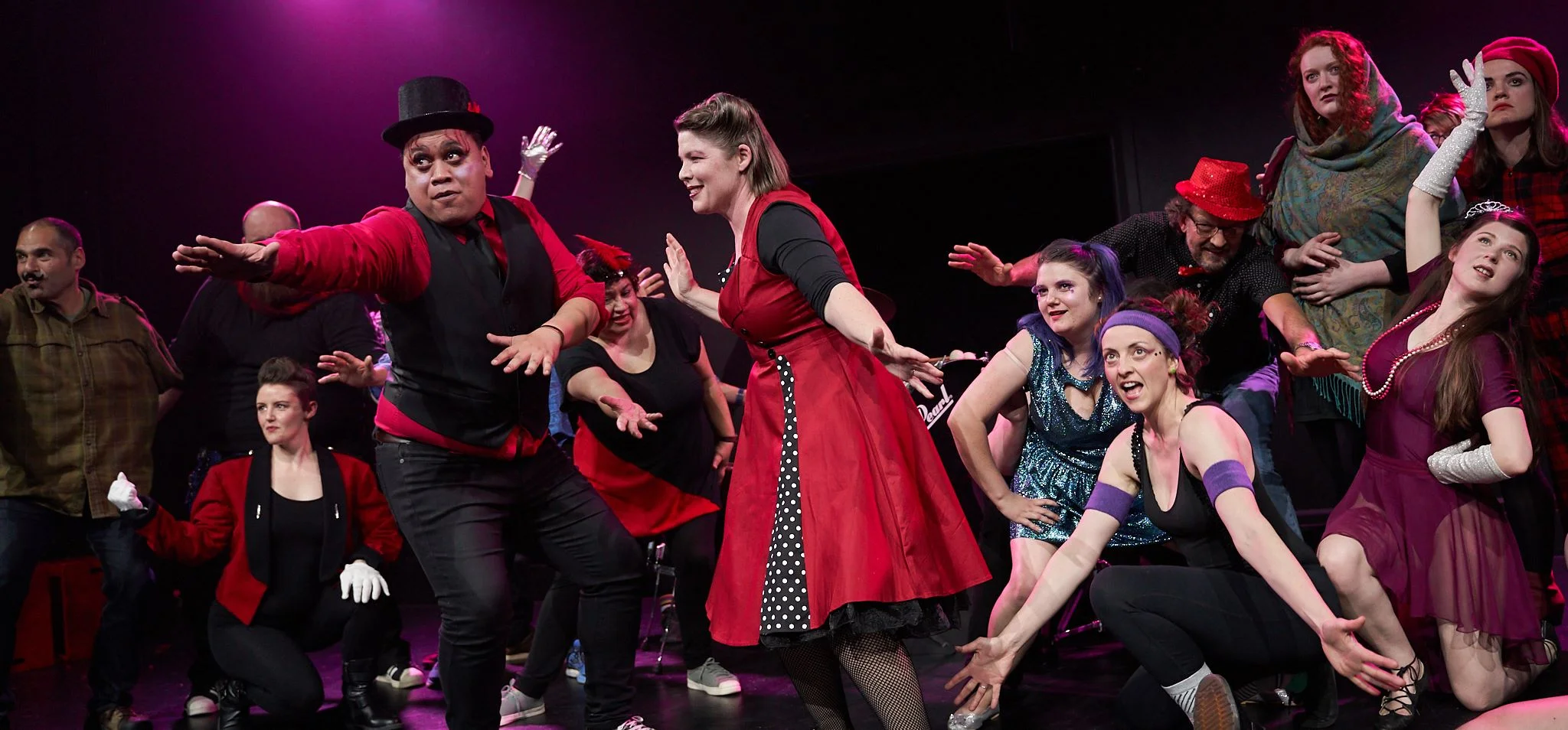 Image from The Greatest Show, NZIF 2018. 12 improvisors in circus performer costumes, posing for the audience in a post-performance tableau.