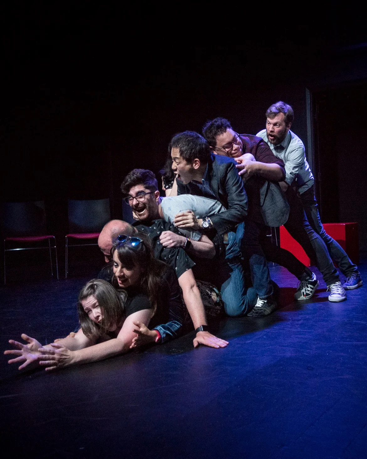 NZIF 2017 NZ vs the World Photo by Ali Little  Image: Seven improvisors piled on top of each other as if stuck down a chute, laughing and shrieking.