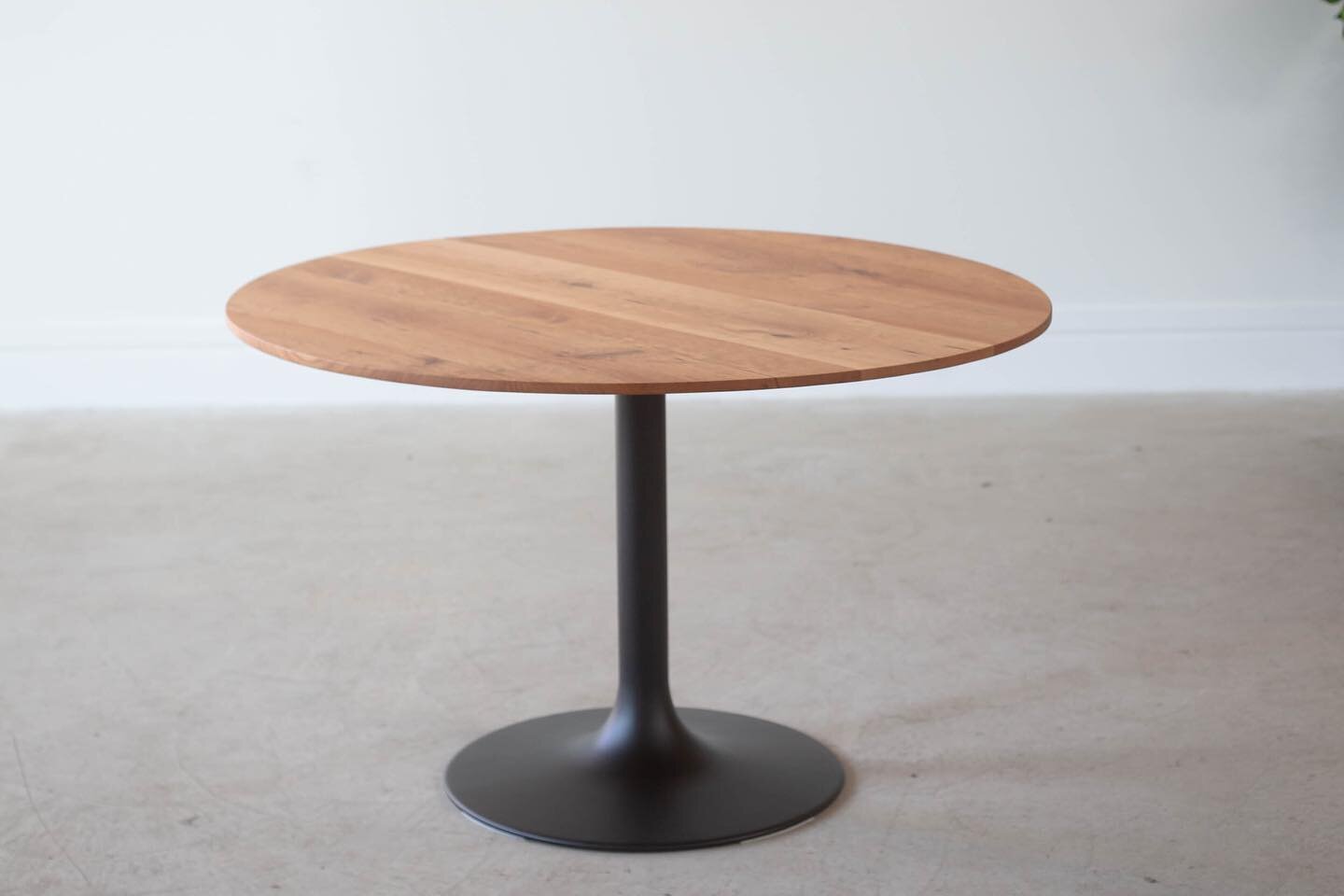This modern dining table is currently available on our website! It is made of solid cherry with a trumpet-style black steel base. The top features a tapered edge profile.

It measures 48&rdquo; diameter and 30&rdquo; overall height and is $1750.

Vie