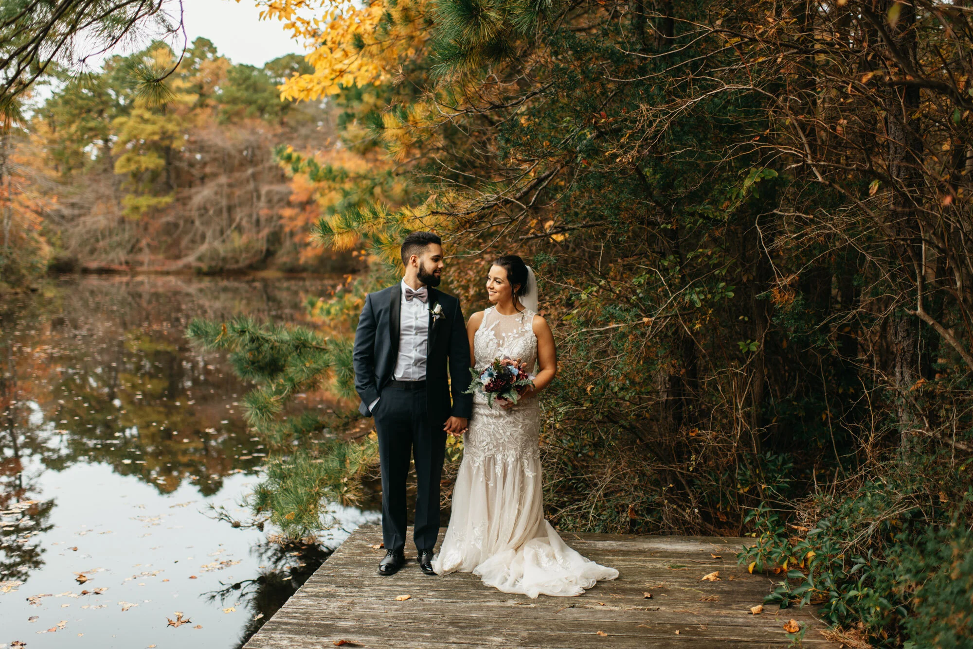 Bride and groom standing on an outdoor stone path surrounded by lush greenery during their wedding at Lakeside at Medford.