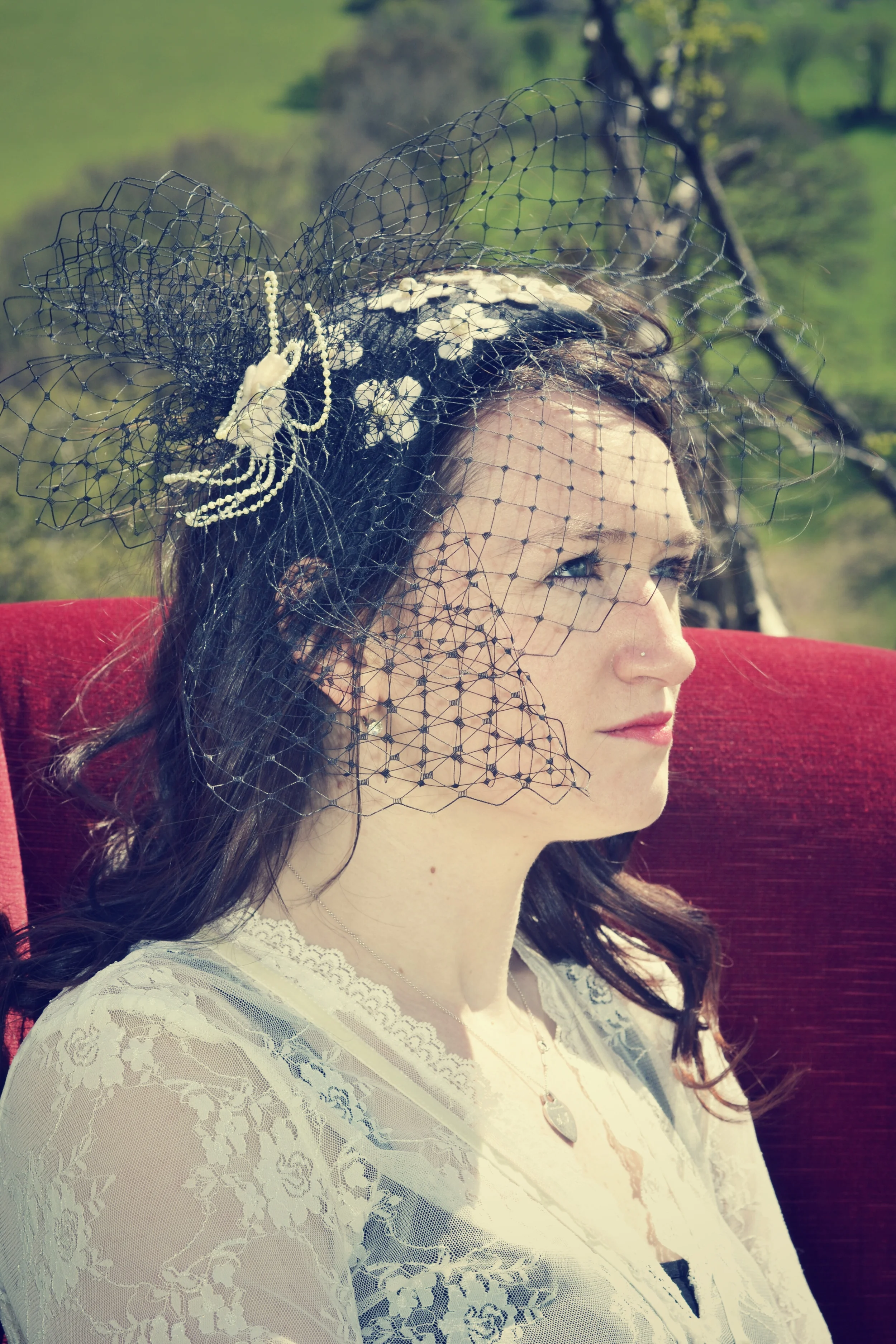 Black velvet crescent headpiece with felt flowers pearl beads and a mass of veiling