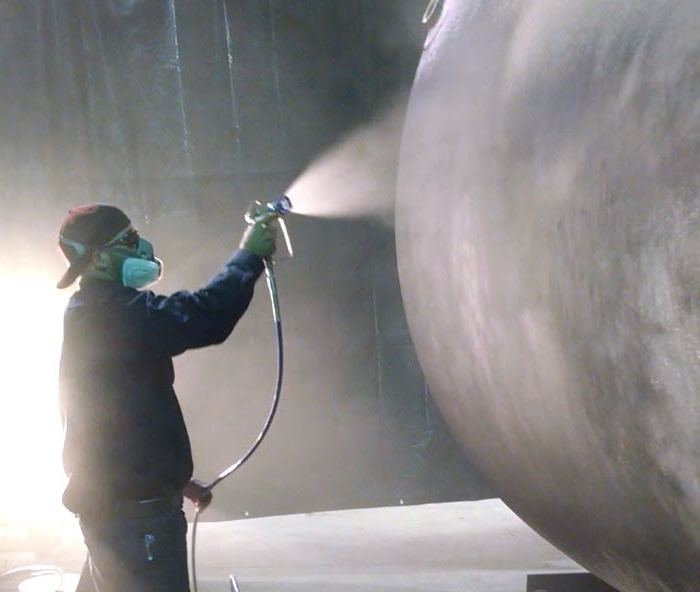 Applying NEETcoat® with an airless sprayer to a fiberglass tank prototype.